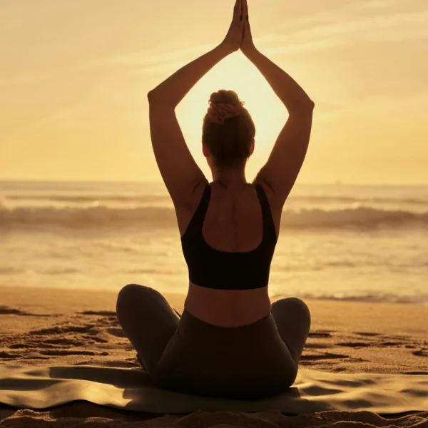 Slim woman doing yoga with raised arms