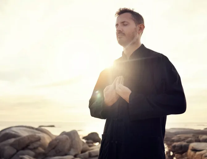 Meditation, zen and tai chi with man at beach for spiritual, fitness and healing energy at sunrise.