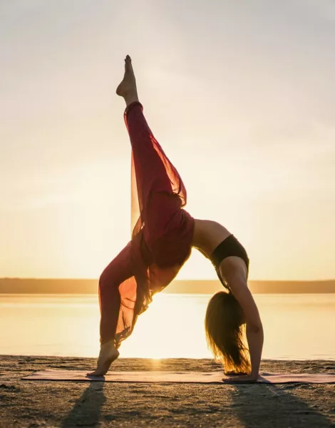 Silhouette yoga woman on the beach at sunset